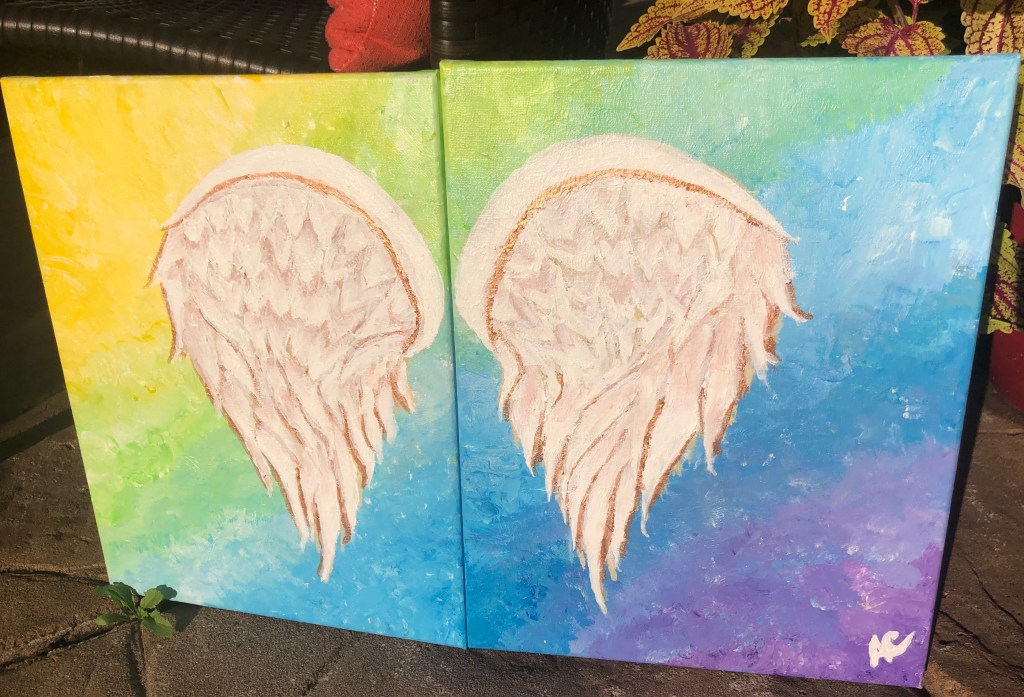 Painting of angel wings on a colorful background.